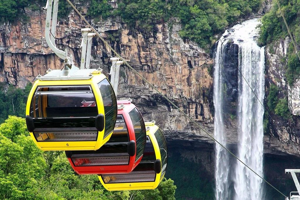 Bondinhos Aéreos sobrevoando a mata com vista para a Cascata do Caracol em Canela